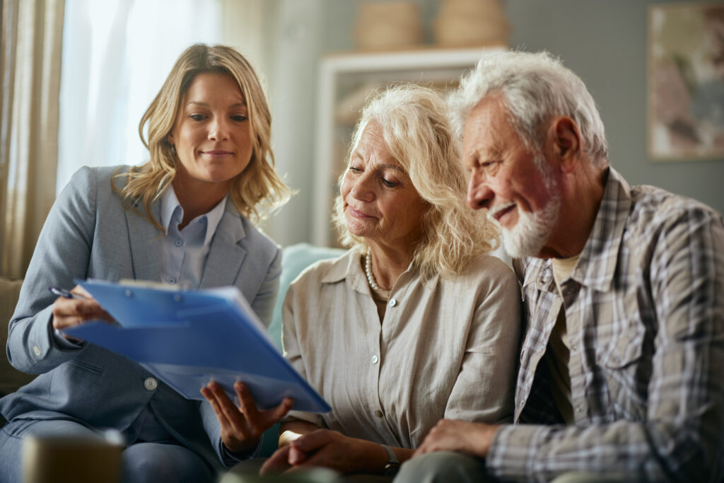 Image of an elderly couple and an attorney reviewing documents, emphasizing Elder Law, Medicare and Medicaid Planning for asset protection in estate planning.