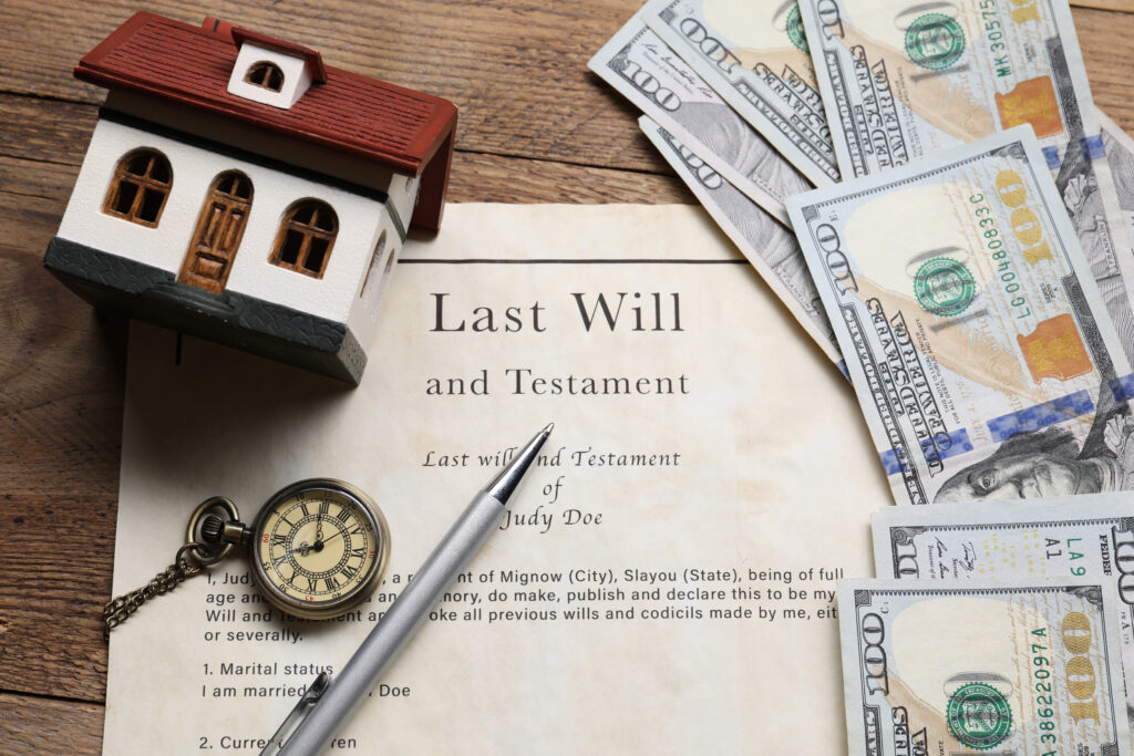 Last will and testament document with house model and cash for asset protection in estate planning.